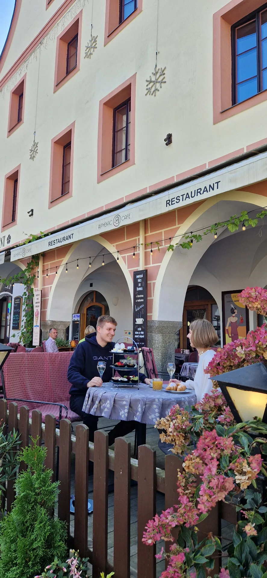 Outdoor terrace of Authentic Café under the arcades on the square